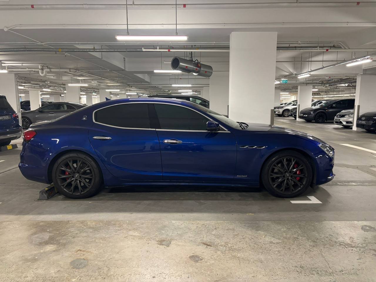 Blue Maserati Ghibli, side profile, parked in a garage